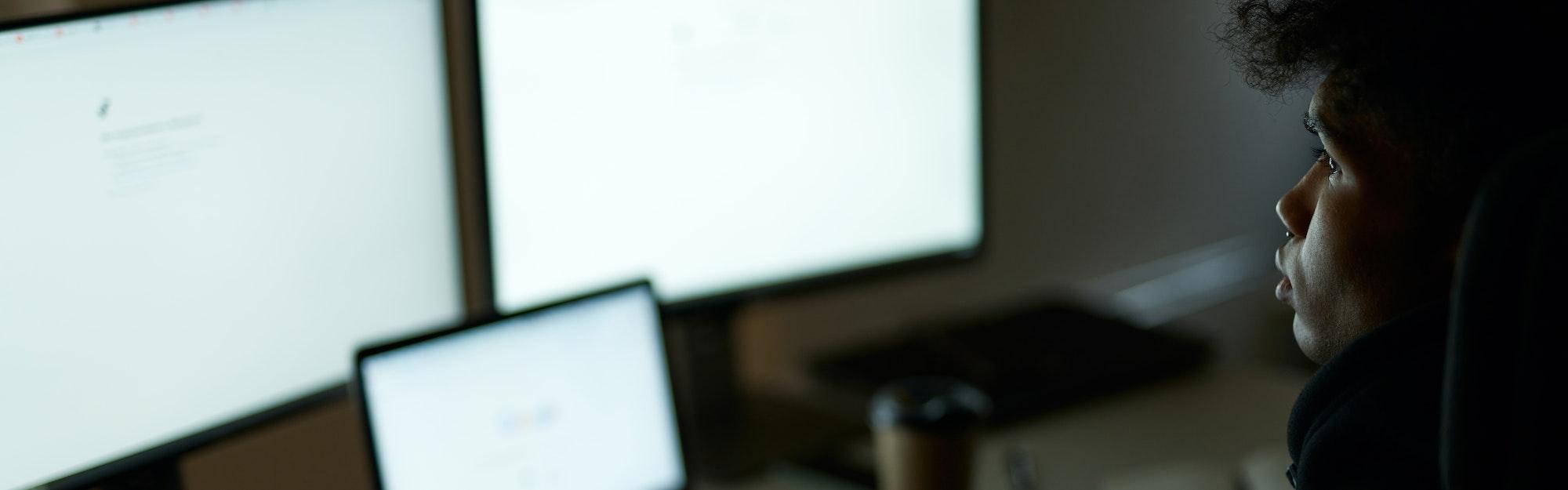 Be busy. Skilled specialist, guy sitting in front of many computer monitors, testing, finishing or