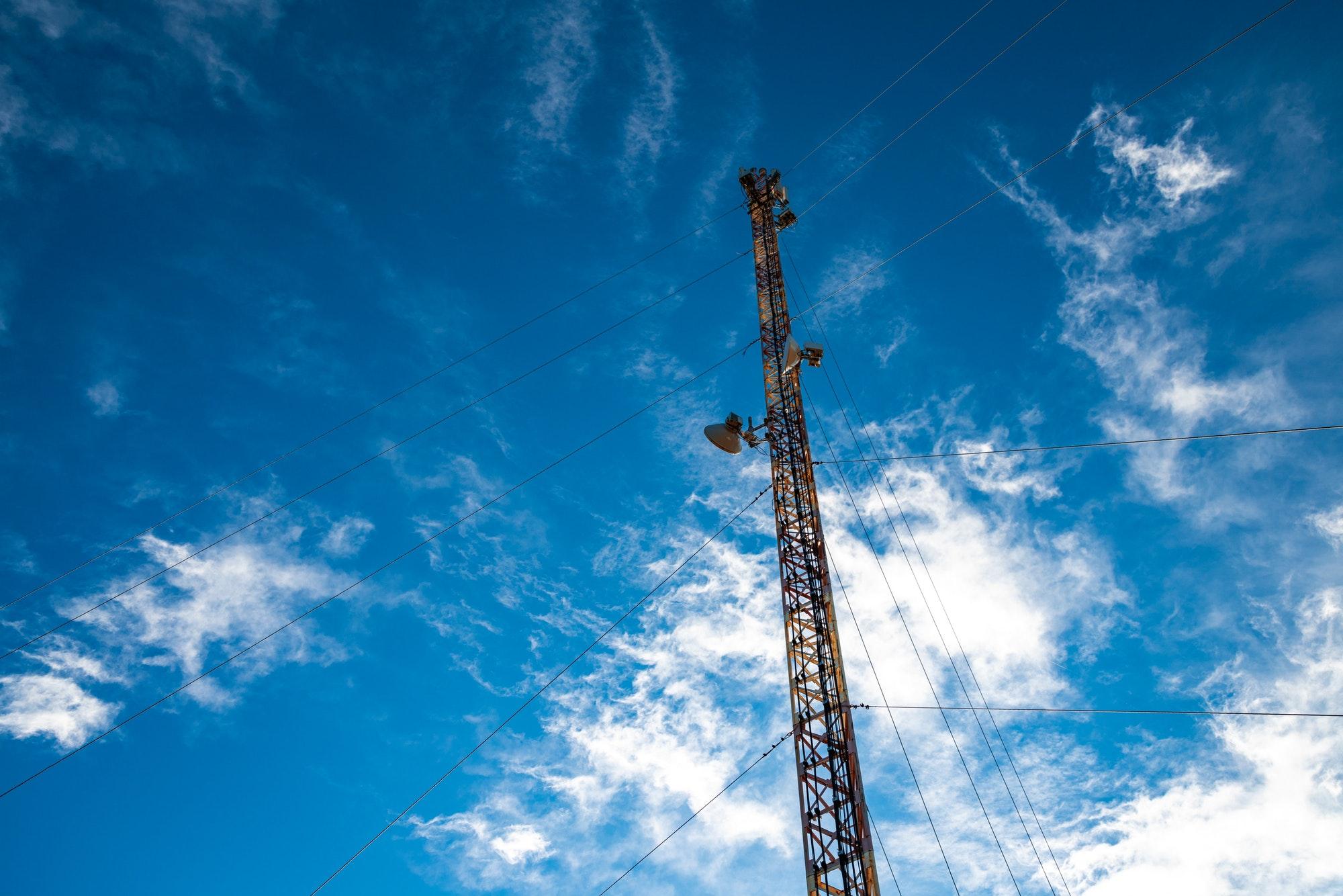 Telecommunication tower against the backdrop of an awesomely beautiful sky with blurry snow-white