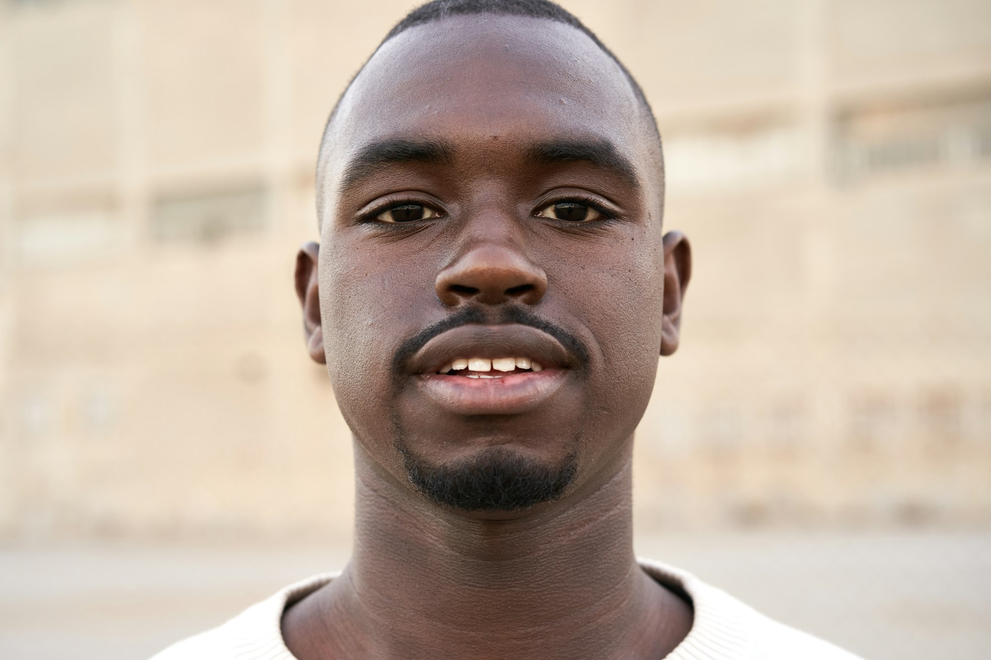 Young african man looking at camera standing outdoors.